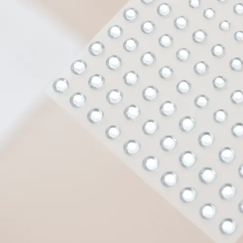 Planche de strass autocollants ronds transparents effet diamant, brillants, de différentes tailles.