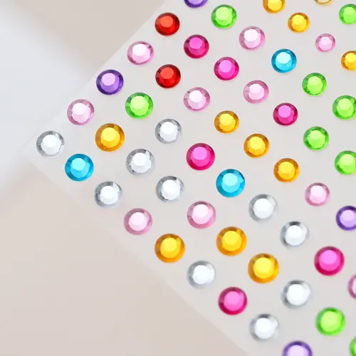 Planche de strass autocollants ronds multicolores de tailles variées, à utiliser pour sur votre visage ou pour personnaliser vos tatouages temporaires.