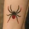 Tatouage temporaire pailleté représentant une araignée.