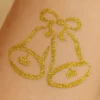 Tatouage éphémère pailleté en forme de cloche.