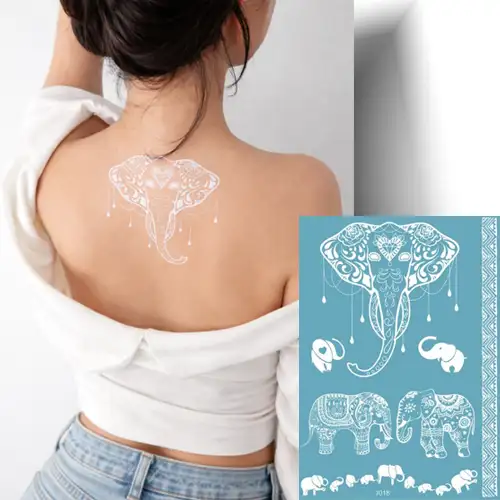 Tatouage éphémère blanc effet henné représentant une tête d’éléphant détaillée, deux silhouettes d’éléphants et des bracelets décoratifs.