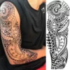 Tatouage éphémère manchette Maorie, motif polynésien de pointe de lance, vague et coquillage pour bras complet.