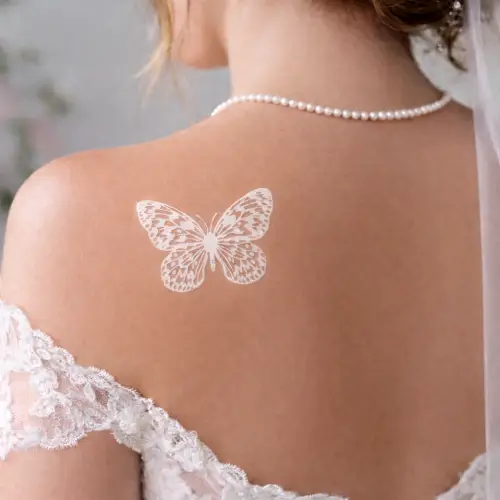 Tatouage papillon blanc éphémère pour mariage – motifs fins style dentelle pour la mariée.