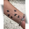 Tatouage minimaliste hirondelle : petits oiseaux noirs représentant la liberté, l'envolée et la chance.
