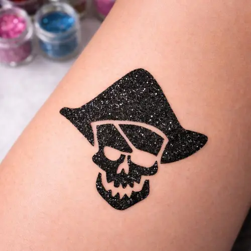 Tatouage pailleté pirate skull réalisé avec des paillettes cosmétiques noires, de la colle cosmétique et un pochoir tatouage adhésif, idéal pour les fêtes et animations enfants.
