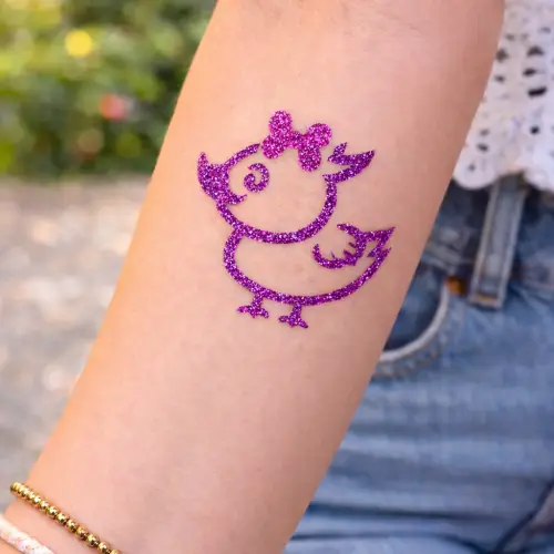 Tatouage éphémère pailleté canard, réalisé avec un stencil adhésif, de la colle cosmétique et des paillettes, idéal pour les enfants et les fêtes.