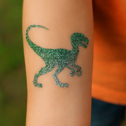 Tatouage pailleté en forme de dinosaure sur le bras d’un enfant, réalisé avec le pochoir 