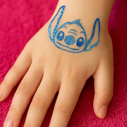 Tatouage temporaire pailleté représentant une tête d’extraterrestre, réalisé avec un pochoir adhésif, de la colle cosmétique et des paillettes.